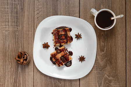 piece of chocolate cake on a white plate, wooden background cup of coffee, a bump, a top viewの写真素材