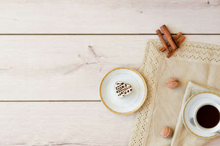 Black coffee in a white cup on a napkin on wooden background, cinnamon, walnut, Pirozhenko in vidde heartの写真素材