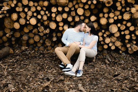 young couple in love on the background of chopped trees, a love storyの写真素材