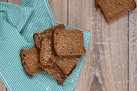 Freshly baked delicious wholewheat bread served on black and read cloth and wooden tray for some...