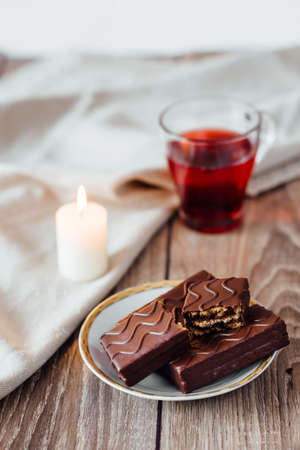 browny cake ready to eat on white dish with coffee cup and magazine book on table topの写真素材