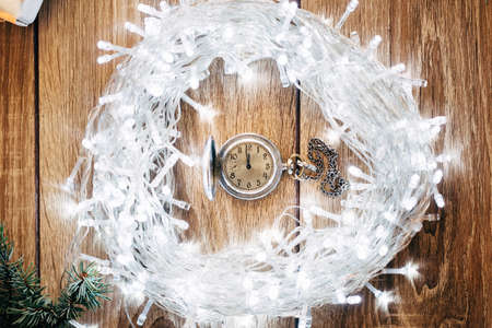 Vintage Clock on Fir Tree Garland Showing Five Minutes to Midnight - Christmas Conceptの写真素材