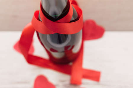 Gift , the heart and the bottle of red wine for a romantic holiday Valentine's day on vintage wooden background.selective focus.の写真素材