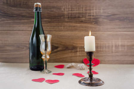 Valentine's Day. wine, candles, small heart on the wooden backgroundの写真素材