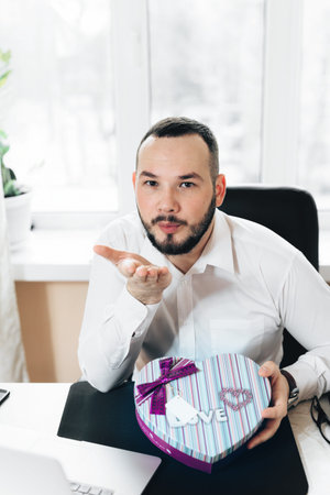 Business bearded man prepared a gift in the form of heart on Valentine's Day