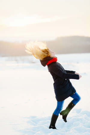 happy young girl on a snow-covered field and a red ballの写真素材