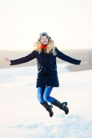 happy young girl on a snow-covered field and a red ballの写真素材