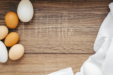 Chicken eggs on a white napkin on a wooden tableの写真素材