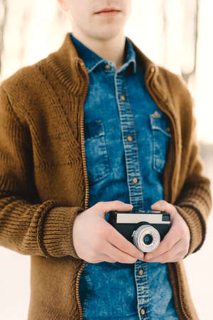 stylish boy with a camera, portrait, winter backgroundの写真素材