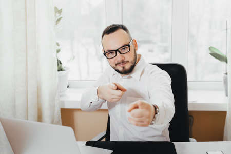 Pretty businesswoman at work in the glasses shows a finger on youの写真素材