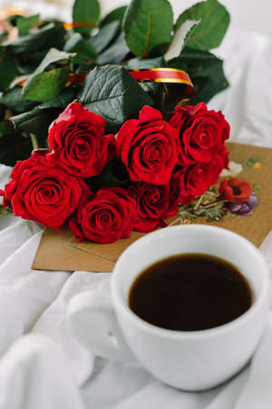 a bouquet of red roses coffee card with congratulations supply in bedの写真素材