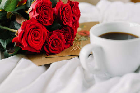 a bouquet of red roses coffee card with congratulations supply in bedの写真素材