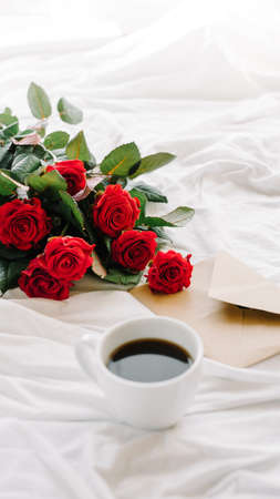 a bouquet of red roses coffee card with congratulations supply in bedの写真素材