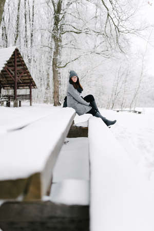 Portrait of a brunette in glasses gray coat with a backpack in the winter, the view zdaleka snowの写真素材