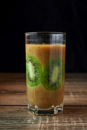 Healthy fresh kiwi cocktail in a glass on a wooden background, sliced kiwi in a glassの写真素材