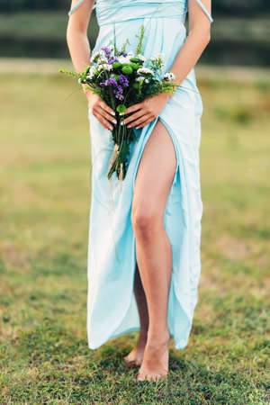 Portrait of a bright curly girl with flowers in a blue dressの写真素材