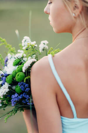 Portrait of a bright curly girl with flowers in a blue dressの写真素材