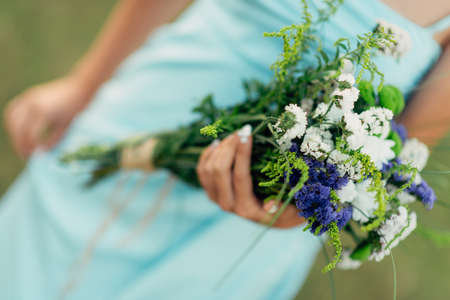 Portrait of a bright curly girl with flowers in a blue dressの写真素材