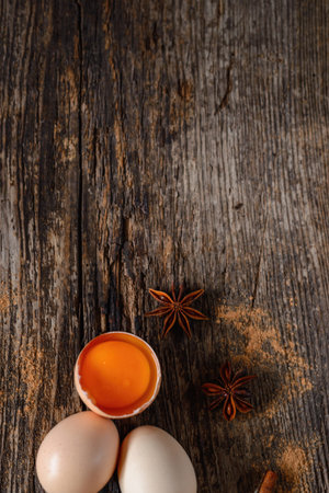 Eggs, cinnamon, baden on an old wooden background