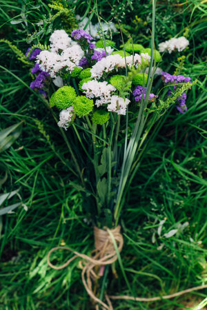 Bouquet of wildflowers with rope on green grassの写真素材