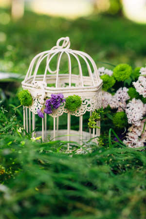 Decoration of the garden. Ancient bird cages with flowers inside decor for the landscapeの写真素材