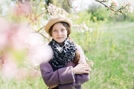 Portrait of a girl in a hat close-up of spring, trees in bloomの写真素材