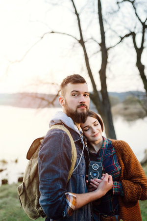 Young tourist couple in the setting sun on the background of a beautiful lake