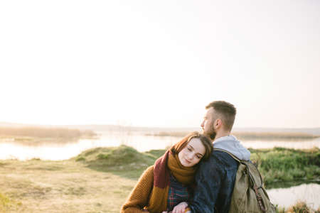 Young tourist couple in the setting sun on the background of a beautiful lakeの写真素材