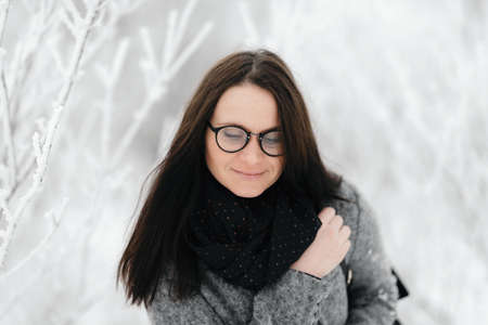portrait of the brunette in glasses gray coat with a backpackの写真素材