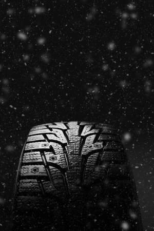 Winter tires. Tires for winter with snow on a black backgroundの写真素材