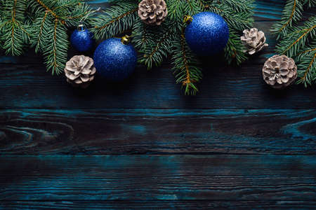 New Year and Christmas decorations Pine tree branches, cones, blue Christmas toys on a wooden background. place for textの写真素材