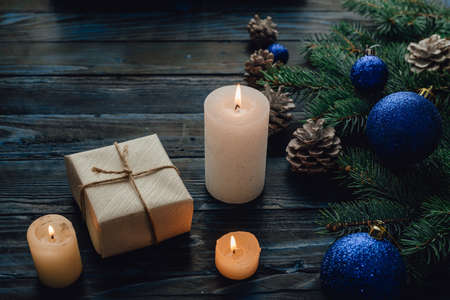 Christmas and Christmas decorations Pine branches of a tree, cones, blue Christmas toys on a wooden background.primary packing space for text New Year's eve and candlesの写真素材