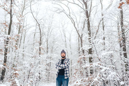 Handsome bearded man in a plaid shirt in the woods, in winterの写真素材
