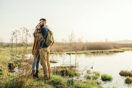 Young tourist couple in the setting sun on the background of a beautiful lakeの写真素材