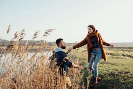 a young couple in love embraces, and fools around on the shore of the lake near the reeds. feelings, emotionsの写真素材