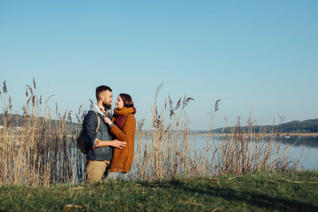 a young couple in love embraces, and fools around on the shore of the lake near the reeds. feelings,...