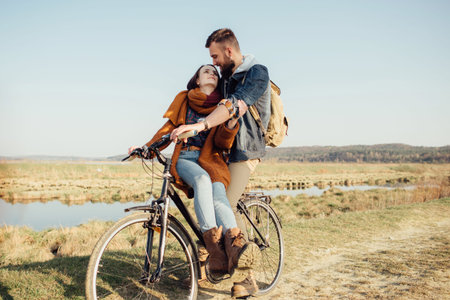 Romantic couple in love. Sunset. A boy and a girl are standing next to a bicycle in nature, sensibilities, emotionsの写真素材