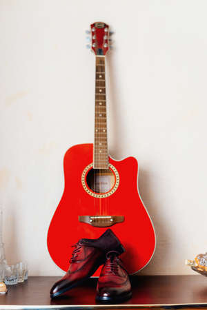 shoes of the groom on a background of red guitar, concept of vintageの写真素材