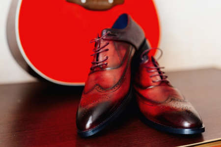 shoes of the groom on a background of red guitar, concept of vintageの写真素材