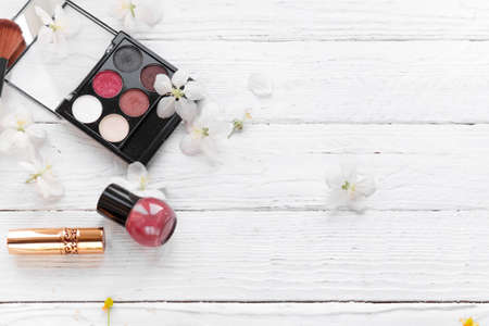 decorative cosmetics for the face, nail polish, white fresh flowers on a light wooden backgroundの写真素材