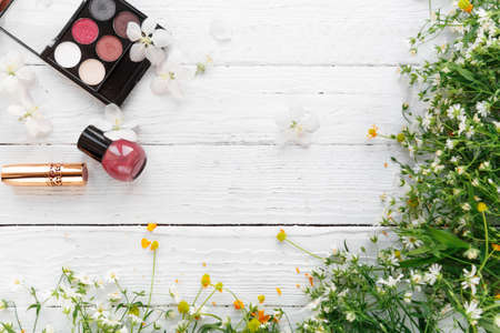 decorative cosmetics and wildflowers on a light wooden backgroundの写真素材
