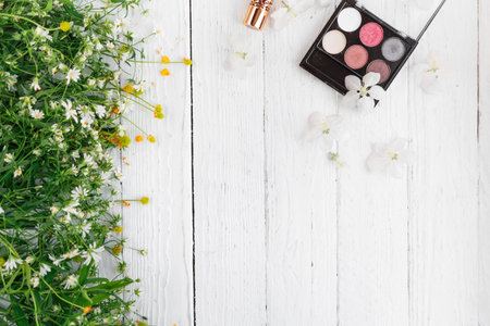 decorative cosmetics and wildflowers on a light wooden backgroundの写真素材