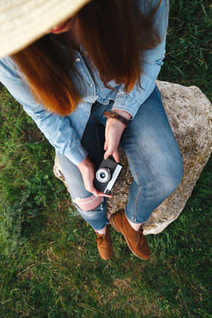 girl in denim clothes with retro camera. View from above. preparing for a good photo, photo for commercials.の写真素材
