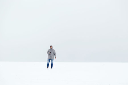 a man in a gray down jacket in a snowy field