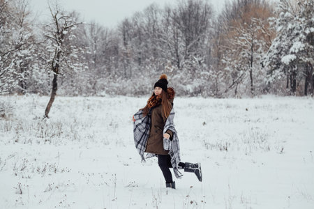 winter portrait of a girl wrapped in a checkered plaidの写真素材