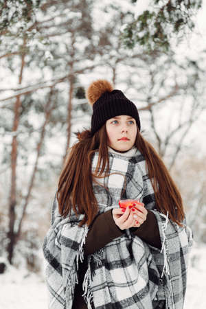 Portrait of a girl in the winter with a candle in a checkered rugの写真素材