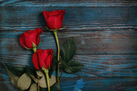 beautiful bouquet of red rose flowers on old blue wooden background, horizontal.の写真素材