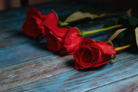 beautiful bouquet of red rose flowers on old blue wooden background, horizontal.の写真素材