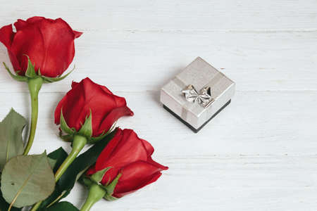 Red roses bouquet and gift box on white wooden background.の写真素材