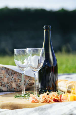 2 glasses of red wine with bread and cheese, pierced on a wooden tray.の写真素材